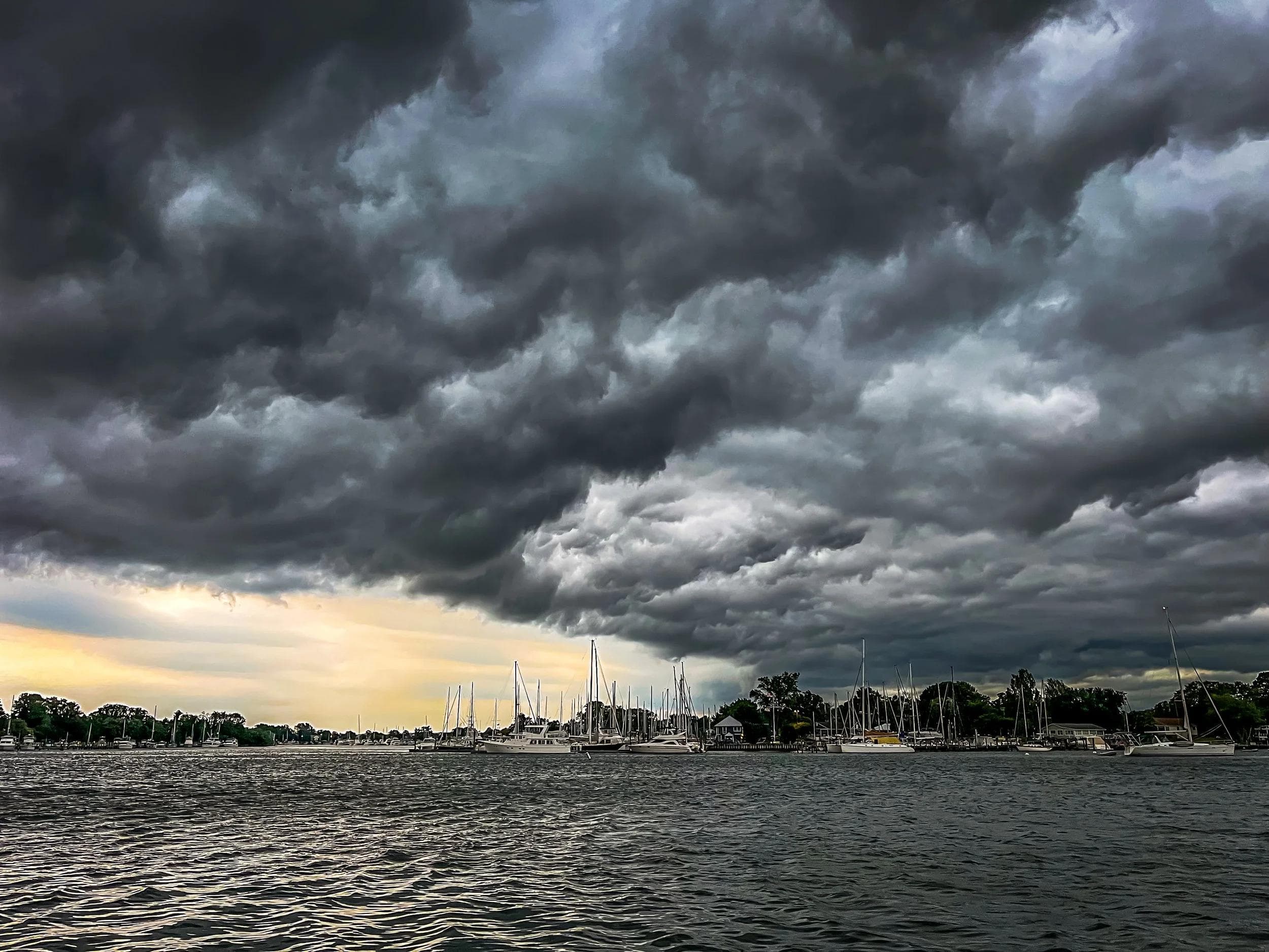 Secured boats in a storage yard with dark hurricane clouds looming overhead in Hollywood, Florida